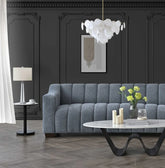 Luxury 3 seater bouclé sofa with deep channel tufting, curved arms and premium textured upholstery in a modern UK living room.