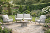 Luxury 4 seater natural rattan garden lounge set with weather-resistant cushions and matching coffee table on a contemporary outdoor patio.