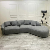 Luxury curved bouclé sofa upholstered in soft textured fabric with deep cushions and a sculptural modern design for contemporary UK living rooms.