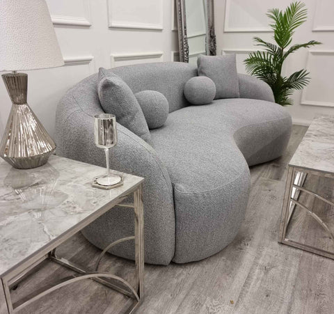 grey Wave bouclé sofa with a sculptural curved silhouette, premium textured upholstery, deep foam cushions, and modern designer styling in a contemporary UK living room.