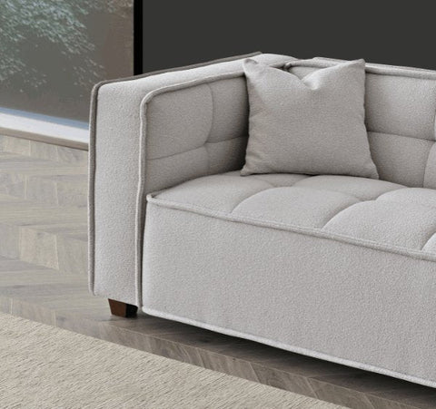  premium putty bouclé fabric featuring Chesterfield-inspired button detailing, bold box arms, and contemporary styling for modern UK living rooms.