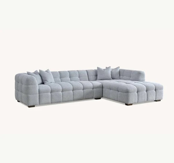 Tribeca pearl bouclé corner sofa with sculptural curved arms, deep channel stitching, premium textured upholstery, and spacious L-shaped seating for modern UK living rooms.