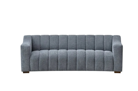 bouclé sofa with deep channel tufting, curved arms and premium textured upholstery in a modern UK living room.