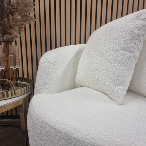 Luxury bouclé accent chair with curved arms and cosy sculptural design.