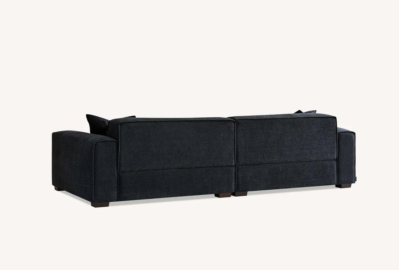 Luxury UK chaise sofa upholstered in soft charcoal bouclé fabric.