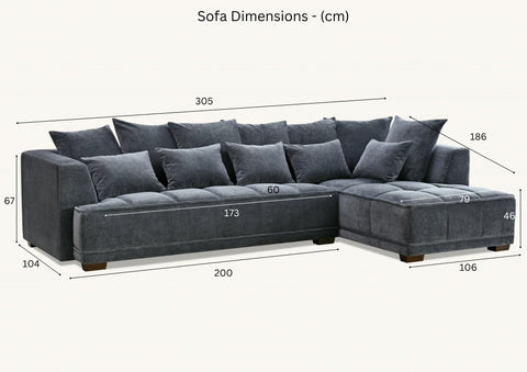 Luxury steel grey velvet corner sofa with deep block-stitched cushions, spacious L-shaped design, and premium upholstery in a modern UK living room.