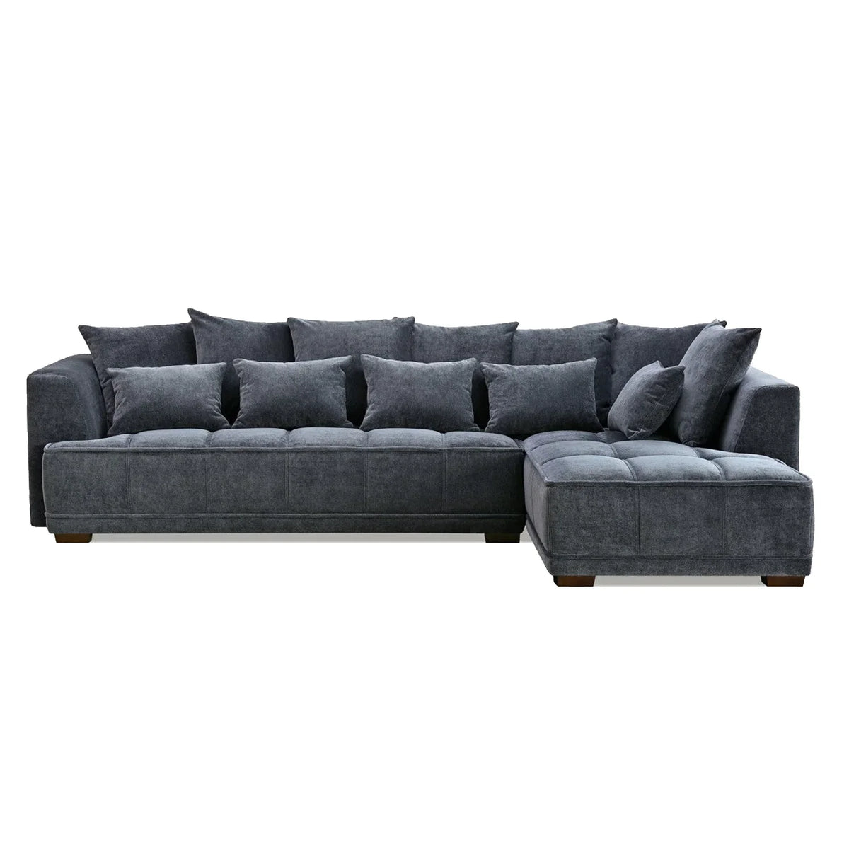 Luxury steel grey velvet corner sofa with deep block-stitched cushions, spacious L-shaped design, and premium upholstery in a modern UK living room.