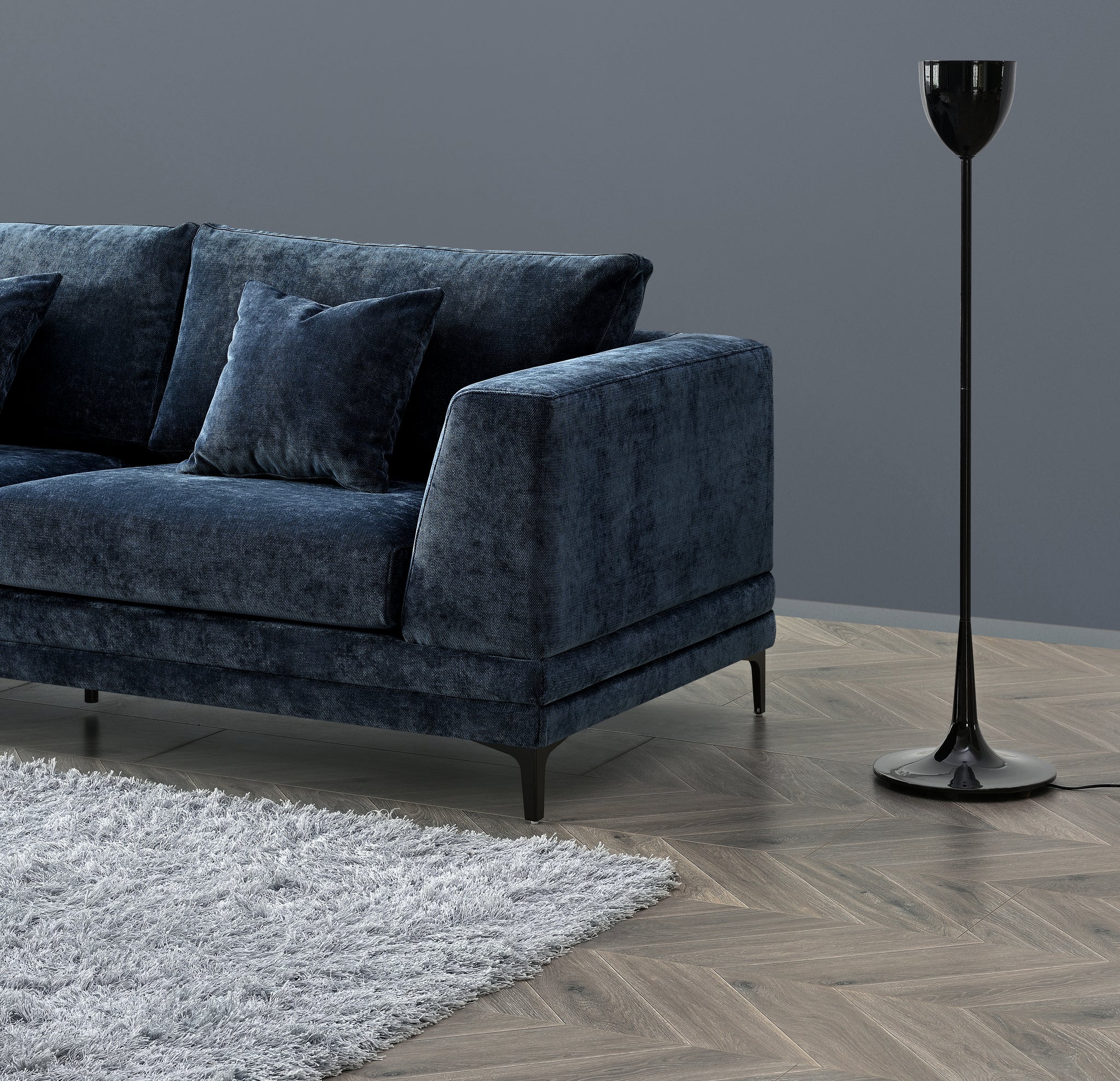 Luxury steel grey velvet sofa with a mid-century modern design, wooden plinth base, deep cushions, and elegant clean lines for contemporary UK living rooms.