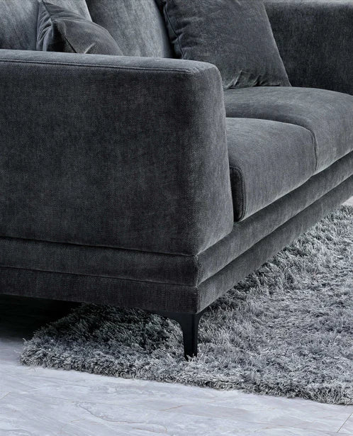 grey velvet sofa with a mid-century modern design, wooden plinth base, deep cushions, and elegant clean lines for contemporary UK living rooms.