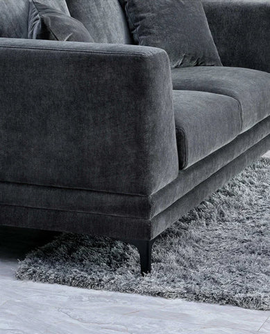 grey velvet sofa with a mid-century modern design, wooden plinth base, deep cushions, and elegant clean lines for contemporary UK living rooms.