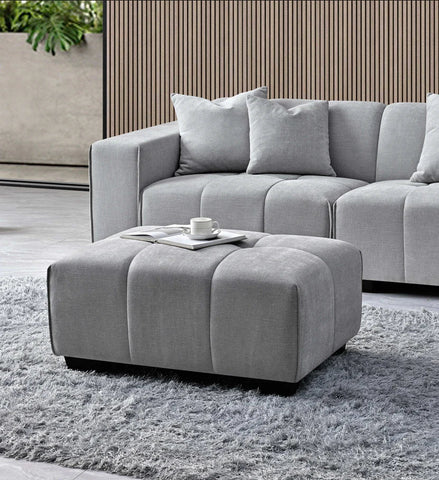 cloudy grey bouclé right-hand corner sofa with modular L-shaped design, block-stitched cushions, and five matching scatter cushions in a contemporary living room.