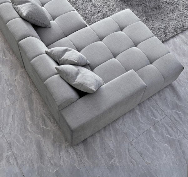 Luxury Leonard modular corner sofa upholstered in cloudy grey bouclé fabric featuring block-stitched cushions, spacious L-shaped seating.