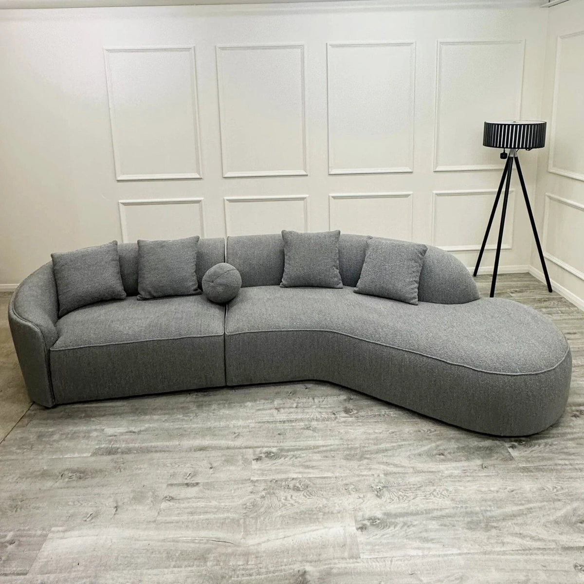 Luxury curved bouclé sofa upholstered in soft textured fabric with deep cushions and a sculptural modern design for contemporary UK living rooms.