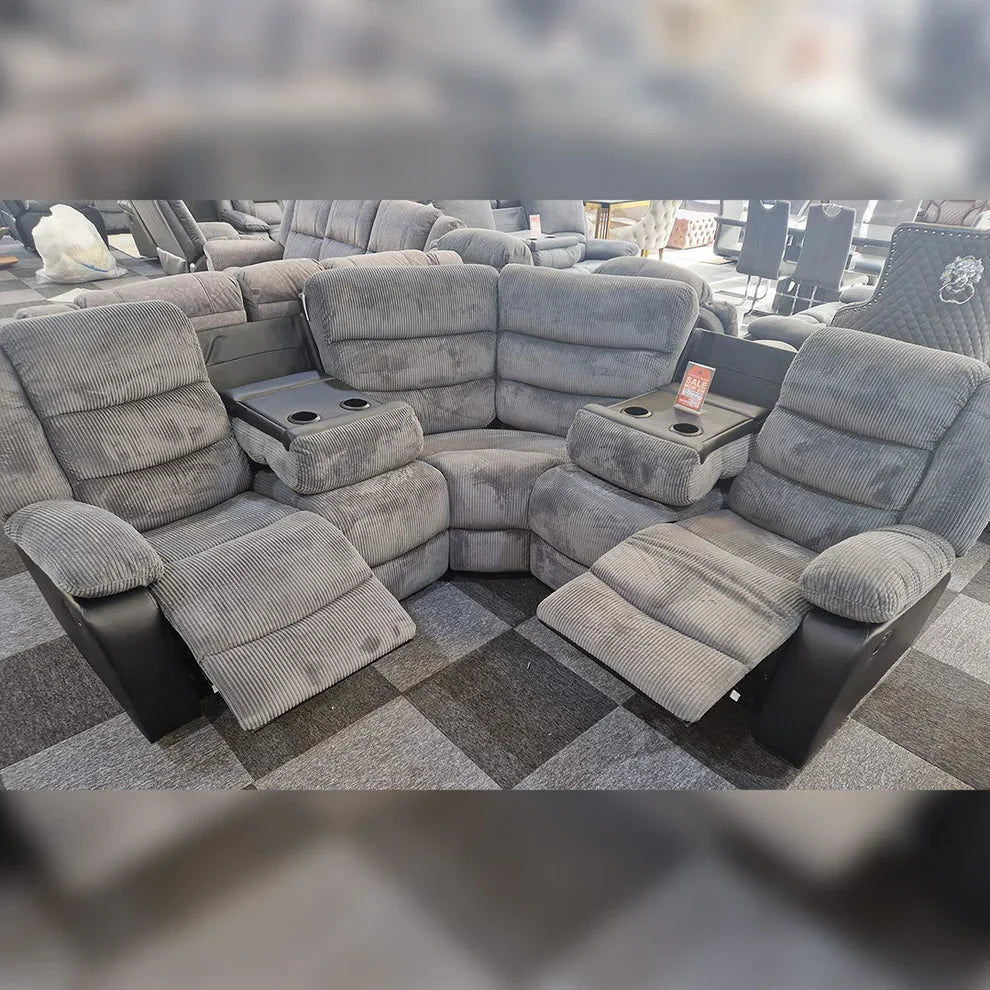Grey jumbo cord fabric corner sofa with manual reclining seats and comfortable padded cushions.