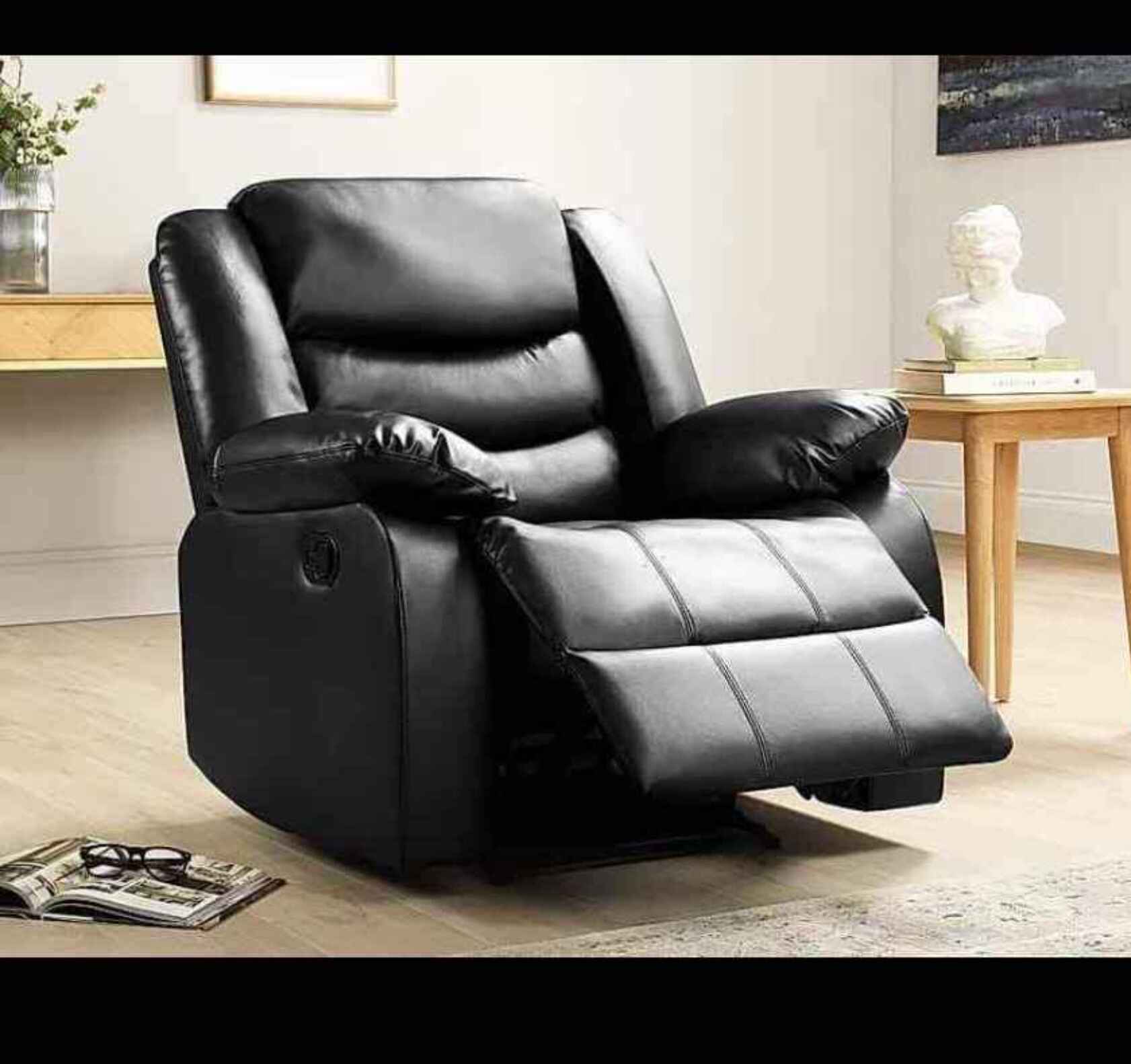 Luxury black leather recliner armchair with manual reclining function for modern UK homes.