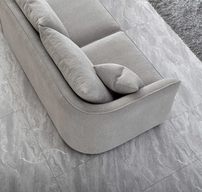 Luxury curved bouclé corner chaise sofa in Pebble and Charcoal with a sculptural organic design, deep cushions, and premium upholstery for modern UK living rooms.