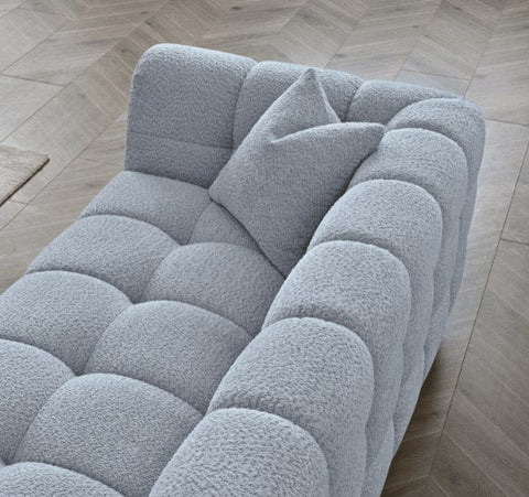 Tribeca Pearl Bouclé sofa featuring sculptural curved arms, deep channel stitching, premium textured upholstery, and contemporary designer styling for modern UK homes.